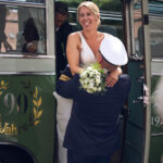 Die Braut wird von Ihrem zukünftigen Mann aus einem Bus gehoben
